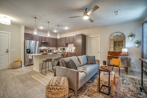 a living room with a couch in front of a kitchen